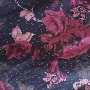 Peut inclure: Un tissu bleu fonc&eacute; avec un motif floral rose. Les fleurs sont dispers&eacute;es sur le tissu et ont une texture scintillante.