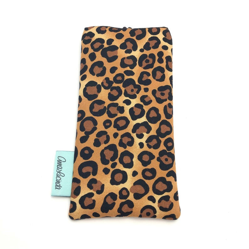 May include: A brown and black leopard print eyeglass case with the text "Anna & Lucinda" on a white tag.