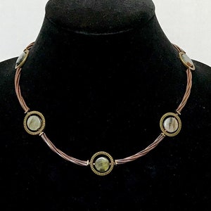May include: A copper wire necklace with five round green and gold gemstone accents.
