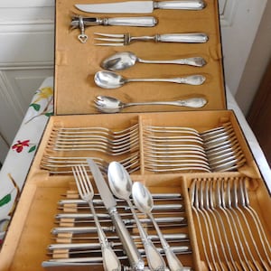 Part of a Louis Schooman silver-plated dessert and serving set. 54-piece cutlery set with shell and rockery decoration.