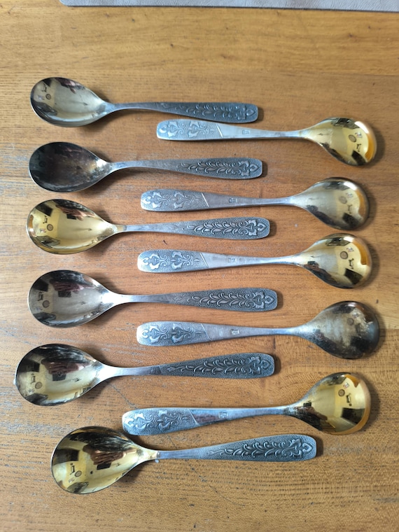 Set of eleven Russian USSR silver and gold metal dessert spoons with leafy decoration