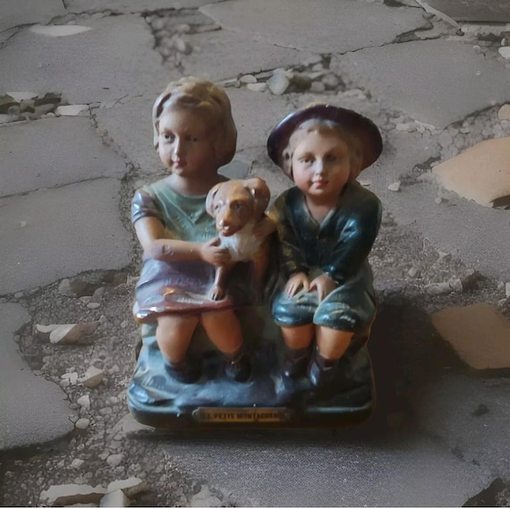 Polychrome plaster subject statue of a boy and a little girl with their dog titled "Le Petit Montagnard"