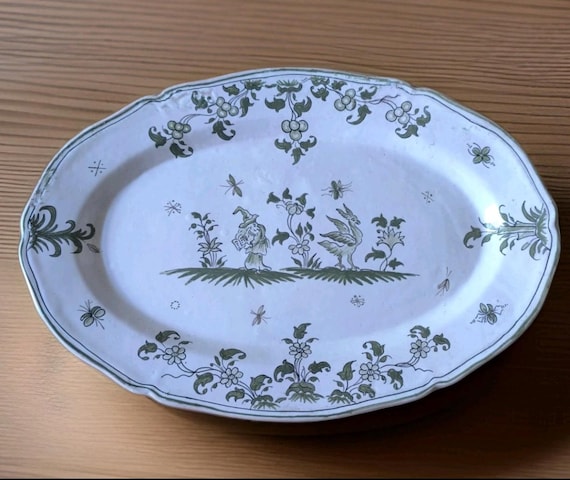 Large Moustiers earthenware dish decorated with grotesques, magician, bird, flowers, French earthenware