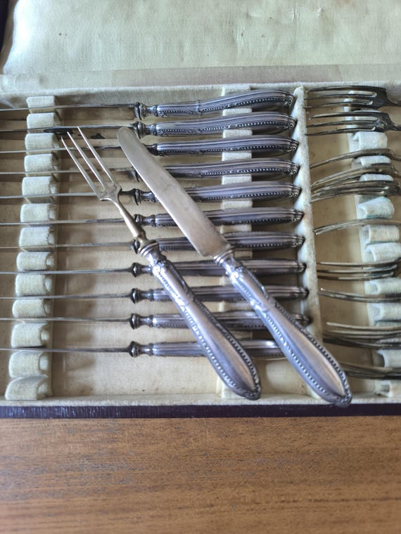 Dessert service in filled silver and brass, 12 forks, 12 knives, LV hallmark, and neck brace in case