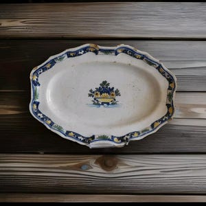 Antique earthenware dish with a flowered basket, origin and period to be determined