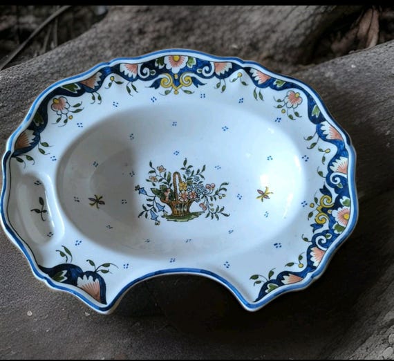 Rouen earthenware shaving dish with painted decoration of a flower basket and insect