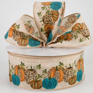 May include: A roll of brown burlap ribbon with a repeating pattern of teal blue and orange pumpkins with leopard print accents. The ribbon is perfect for fall crafts and decorating.