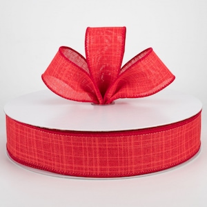 May include: A spool of red checkered ribbon with a bow tied on top. The ribbon is made of a textured fabric and has a subtle sheen.