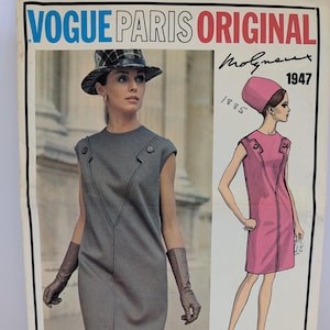 Puede incluir: Ilustración de moda vintage Vogue Paris Original de 1947. La imagen presenta a una mujer con un vestido gris y un boceto de moda de un vestido rosa. El texto "Vogue Paris Original" se muestra en la parte superior.