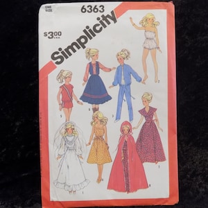 May include: Simplicity sewing pattern number 6363 for making doll clothes. The pattern includes eight different outfits for a doll, including a red and white sports outfit, a blue and white dress, a blue jacket and pants, a white wedding dress, a yellow floral dress, a red cape, and a brown and white dress.