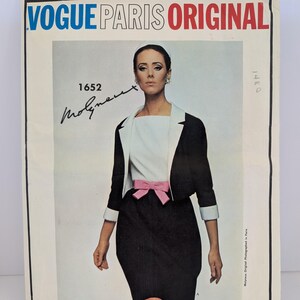 Puede incluir: Patrón original de Vogue Paris vintage. La portada muestra a una mujer con un atuendo en blanco y negro con un lazo rosa. El texto "VOGUE PARIS ORIGINAL" está en azul y rojo. El número de patrón es "1652" con una firma.
