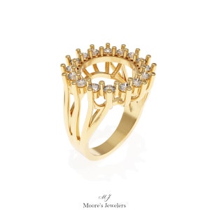Könnte beinhalten: Ein goldener Ring mit einer runden, offenen Fassung, die von einem Heiligenschein aus kleinen Diamanten umgeben ist. Der Ring hat ein filigranes, kompliziertes Design mit mehreren Bändern.
