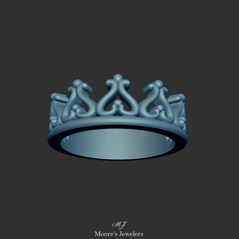 May include: A silver crown ring with intricate details. The ring is made of metal and has a smooth, polished finish.