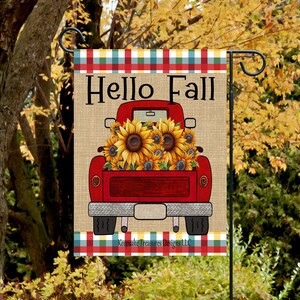 Może przedstawiać: Czerwony samochód dostawczy z tłem z płótna jutowego jest wypełniony słonecznikami. Samochód ma białe tablice rejestracyjne, a tekst "Hello Fall" jest napisany czarnym kolorem nad samochodem. Tekst "Keepsake Treasures Designs LLC" jest napisany czarnym kolorem na dole obrazu.