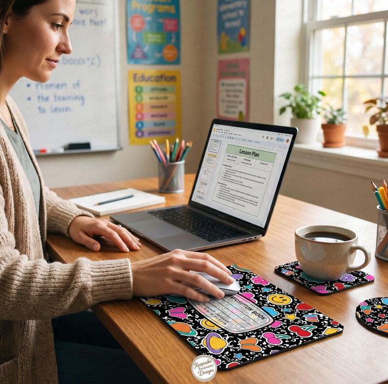 Pu&ograve; includere: Un tappetino per mouse nero con un colorato design a quaderno, con pianeti, faccine sorridenti e altre forme giocose. Un laptop, una tazza di caff&egrave; e sottobicchieri abbinati sono su una scrivania di legno. Il testo "Composition Book" &egrave; visibile.