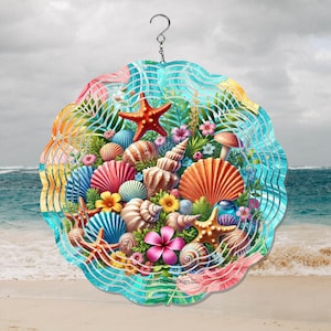 May include: A colorful, round wind spinner featuring a beach scene with seashells, starfish, and tropical flowers. The design includes a variety of shells in shades of pink, orange, blue, and white, with a red starfish and a hook for hanging.