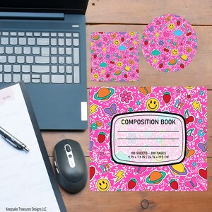 Op de afbeelding: Een compositieboek, vierkante coaster en ronde coaster met een roze achtergrond en illustraties van smiley gezichten, aardbeien en planeten. Het compositieboek heeft de tekst "COMPOSITION BOOK" en meet 24,76 x 19,0 cm.