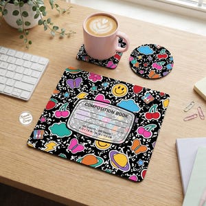 Pu&ograve; includere: Un set di quaderno, sottobicchiere e tazza con sfondo nero e grafica a cartoni animati colorati. Il quaderno misura 24,76 x 19,0 cm. Il set include una tazza rosa con un latte e un sottobicchiere abbinato.