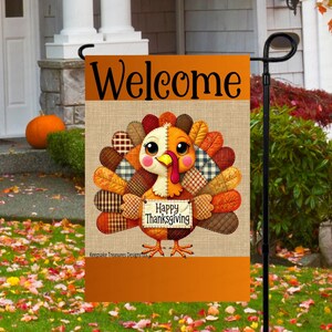 May include: Thanksgiving garden flag with a cartoon turkey design. The flag features the word "Welcome" at the top and a turkey holding a sign that says "Happy Thanksgiving". The turkey has a patchwork design with orange, brown, and white colors.