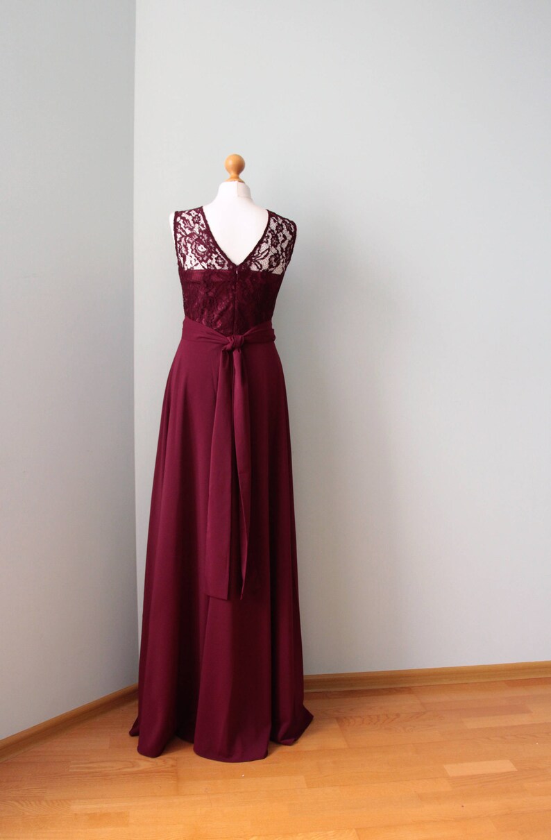 May include: A burgundy maxi dress with a lace bodice and a sash tie at the waist.