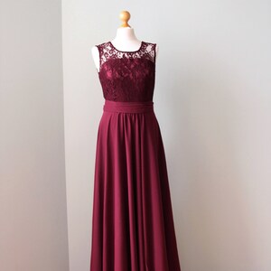 May include: A burgundy sleeveless maxi dress with a lace bodice and a simple, flowing skirt.