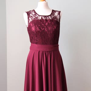 May include: A burgundy sleeveless maxi dress with a lace bodice and a satin sash.
