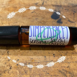 Sensing sacral chakra essential oil blend in glass roller bottle