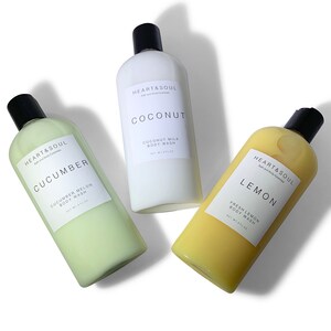 May include: Three clear plastic bottles of body wash with white labels. The bottles are labeled "HEART & SOUL" and contain the scents "COCONUT", "CUCUMBER", and "LEMON".