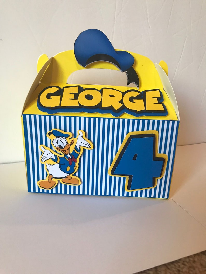 Pode incluir: Uma caixa de lembrancinhas de festa amarela e azul com um personagem do Pato Donald, o nome "GEORGE" e o n&uacute;mero "4" impressos nela.