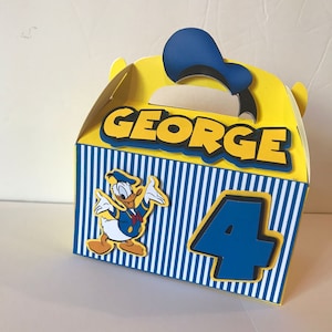 Pode incluir: Uma caixa de lembrancinhas de festa amarela e azul com um personagem do Pato Donald, o nome "GEORGE" e o n&uacute;mero "4" impressos nela.