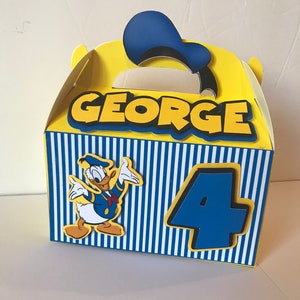 Pode incluir: Caixa de lembrancinha amarela e azul com um personagem do Pato Donald, o nome "GEORGE" e o n&uacute;mero "4" na frente.