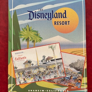May include: A brochure for The Disneyland Resort in Anaheim, California. The brochure features a colourful illustration of the resort's entrance and a blue sky with white clouds. The text "Introducing... Disney's California Adventure" is visible in the image.