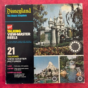 Puede incluir: Una caja vintage de 21 carretes parlantes Disneyland View-Master. La caja presenta una imagen colorida del Castillo de la Bella Durmiente y una descripción de los carretes: "Color completo, realismo 3D. Escucha lo que cada escena cuenta. Una nueva combinación emocionante de la vista 3D y el sonido."