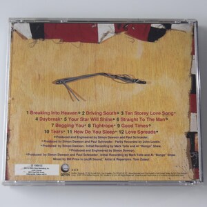 May include: A CD case with a textured, tan background and a design featuring red, white, and black elements. The back of the CD case displays a tracklist with song titles and production credits.