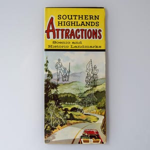 May include: A vintage travel guide titled "SOUTHERN HIGHLANDS ATTRACTIONS." The cover is yellow with red and black text, featuring illustrations of scenic landscapes, historic landmarks, and a red car driving on a winding road.