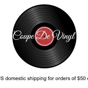 May include: A black vinyl record with the text "Coupe De Vinyl" in white script. The center label is red with a white border. The record is set against a white background.