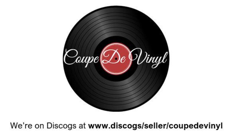 May include: A black vinyl record with the text "Coupe De Vinyl" in a cursive font. The center label is red with a white border. The image is on a white background.