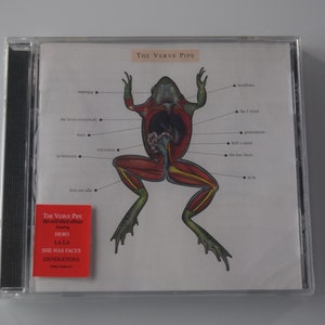 May include: A CD case with a red and white sticker that says "The Verve Pipe" and lists the songs "Hero", "La La", and "She Has Faces Generations". The front of the case features a diagram of a frog with its internal organs labeled.
