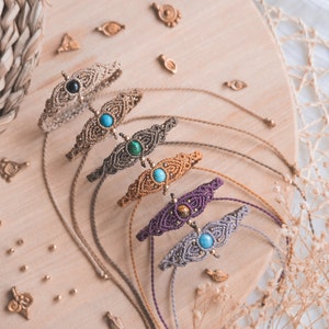 May include: Five macrame bracelets with different colored stones and beads. The bracelets are made with a variety of knots and patterns. The stones are turquoise, tiger's eye, malachite, and black onyx.