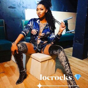 May include: A woman wearing a blue and white patterned pajama top and matching shorts, with black thigh-high boots. She is sitting on a white stool with her hair pulled back in a bun. The text "locrocks" is written in white on a black background.