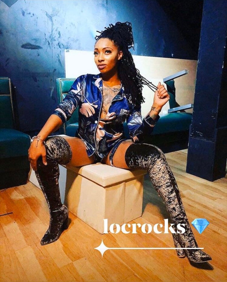 May include: A woman wearing a blue and white patterned pajama top and matching shorts, with black thigh-high boots. She is sitting on a white stool with her hair pulled back in a bun. The text "locrocks" is written in white on a black background.