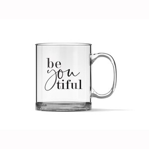 May include: A clear glass mug with a black inscription that reads "be you tiful".