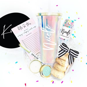 May include: A gift basket with a pink and blue iridescent tumbler with the name "Nicole" on it, a small jar of confetti with the name "Nicole" on it, a notepad with the text "Let's do this" and a list of things to do, a candle, and cookies.