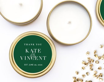 Peut inclure: Trois petites boîtes de bougies dorées avec des bougies blanches. Une boîte a une étiquette verte avec le texte "Thank You Kate & Vincent Est. June 25, 2024".