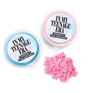 May include: Two small containers of pink and blue kinetic sand with labels that read "In My Teenage Era" and "Teagan's 13th Birthday".