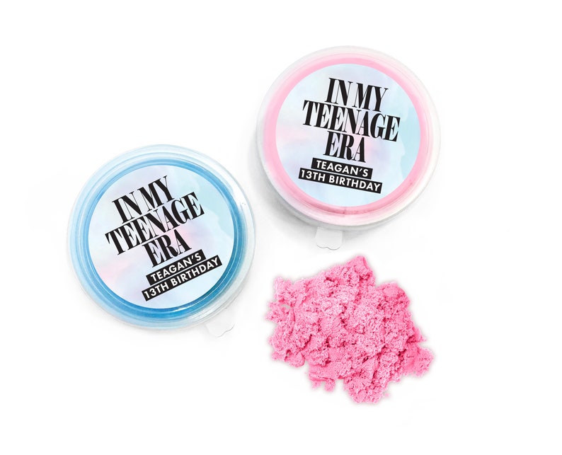 May include: Two small containers of pink and blue kinetic sand with labels that read "In My Teenage Era" and "Teagan's 13th Birthday".