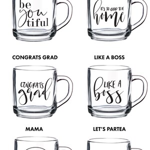 May include: Six different glass mugs with black lettering. The mugs feature the following text: "be you tiful", "it's so good to be home", "congrats grad", "like a boss", "mama", and "let's partea".