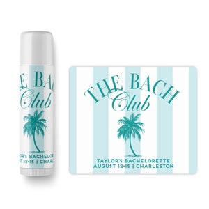 May include: A white lip balm tube with a teal palm tree and the text "The Bach Club" on the front. The text "LOR'S BACHELOR AUGUST 12-15 | CHARL" is printed on the bottom of the tube. A teal and white striped sticker with the text "THE BACH Club" and a teal palm tree is also included. The text "TAYLOR'S BACHELORETTE AUGUST 12-15 | CHARLESTON" is printed on the bottom of the sticker.