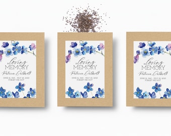 May include: Three seed packets with floral designs and the text "In Loving Memory." Each packet features blue and purple watercolor flowers, the name Patricia Caldwell, and dates. A scattering of seeds is above the packets.
