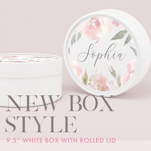 K&ouml;nnte beinhalten: Eine wei&szlig;e runde Box mit einem gerollten Deckel. Der Deckel hat ein Blumenmuster mit rosa und gr&uuml;nen Aquarellblumen und den Namen "Sophia" in Kursivschrift. Die Box hat einen Durchmesser von 9,5 Zoll.